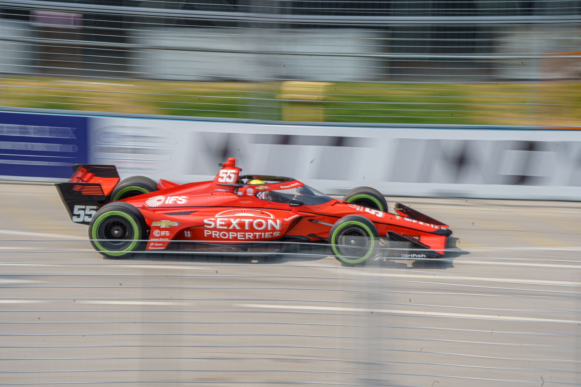 Red racing car in motion during a race in Toronto, Canada, showcasing speed and excitement.