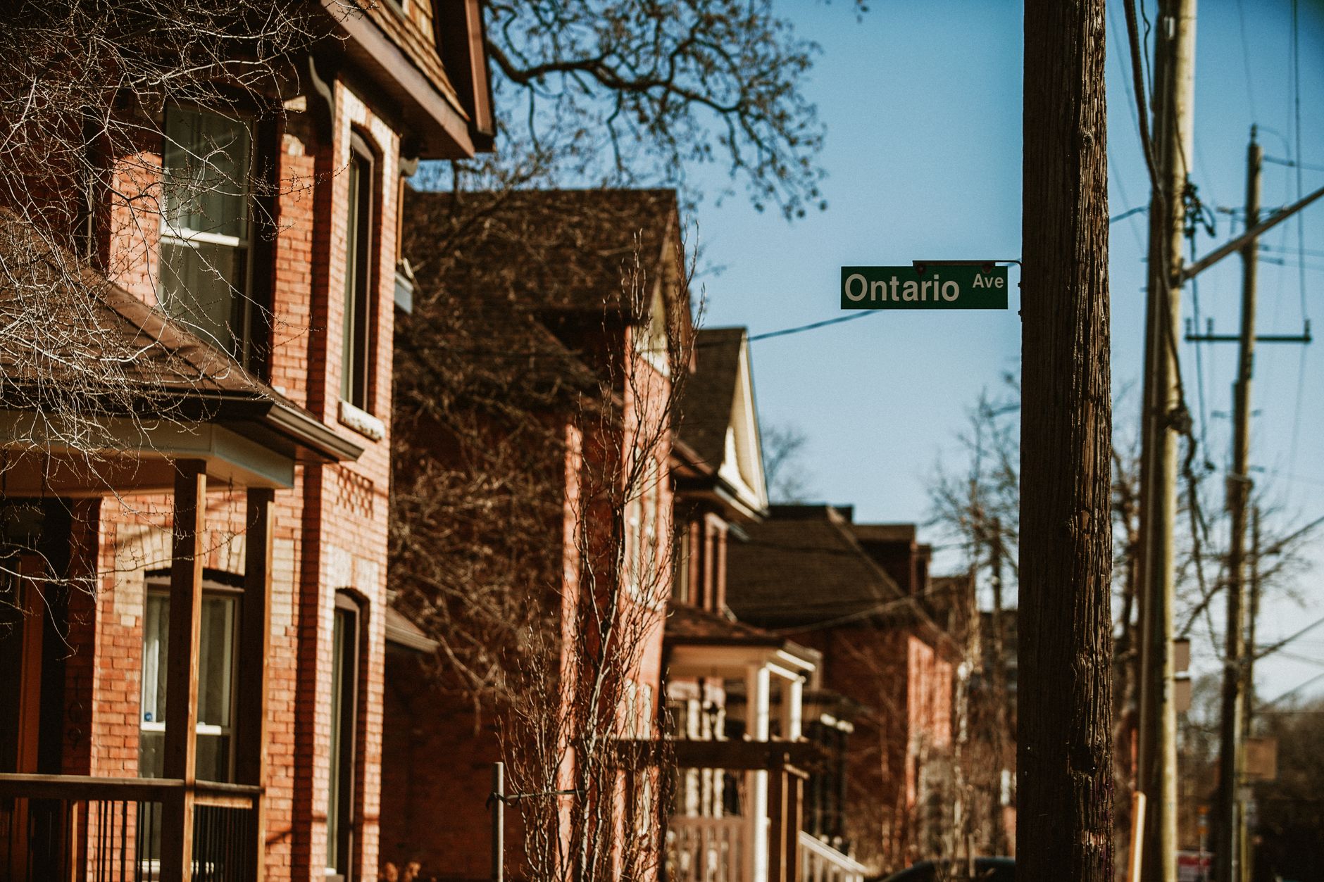 Historic brick homes on Ontario Ave in Hamilton, Canada, capturing a warm urban street scene.