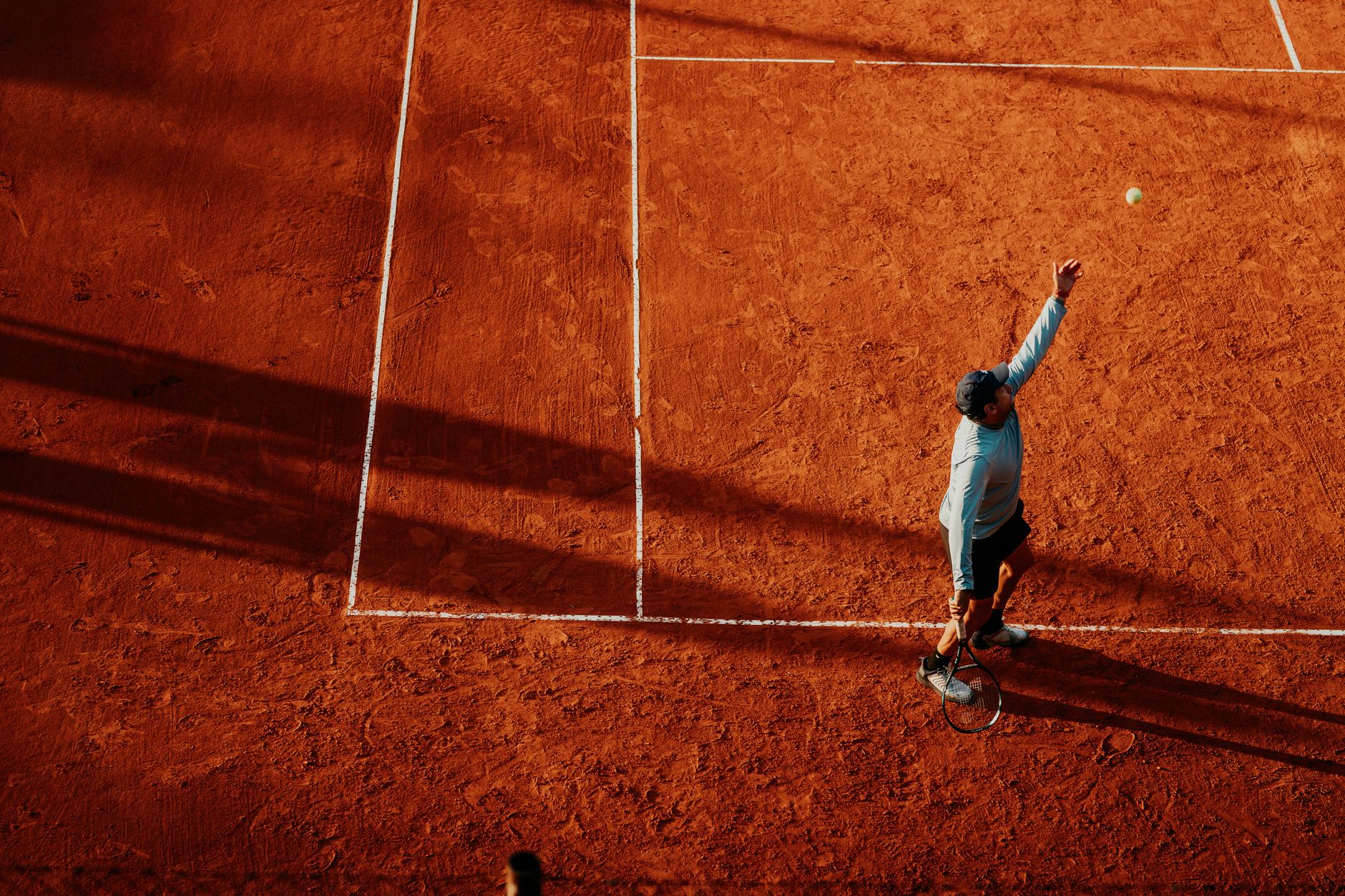 Aerial view of a tennis player serving on a clay court in Buenos Aires, Argentina.