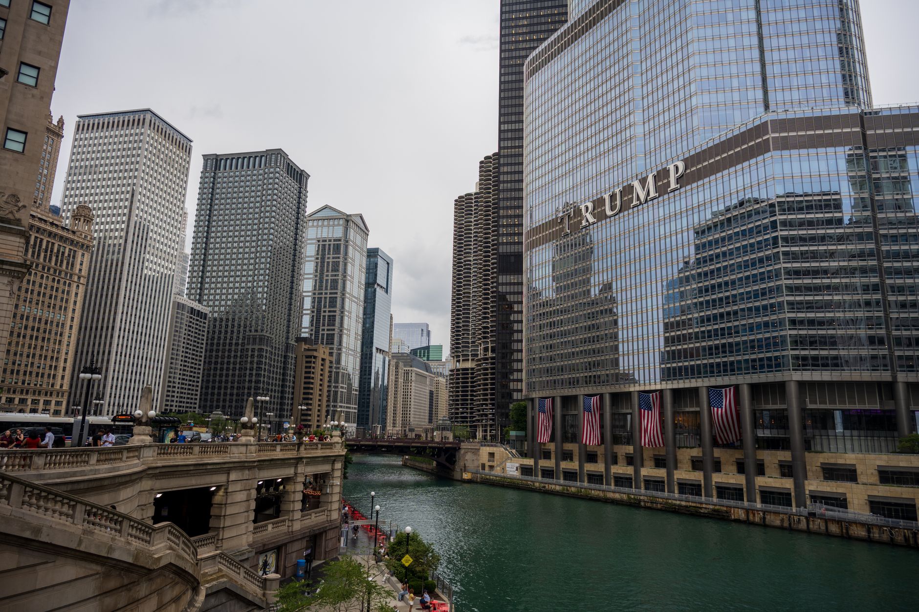 Scenic view of Chicago River with iconic skyscrapers and Trump Tower, capturing city life.