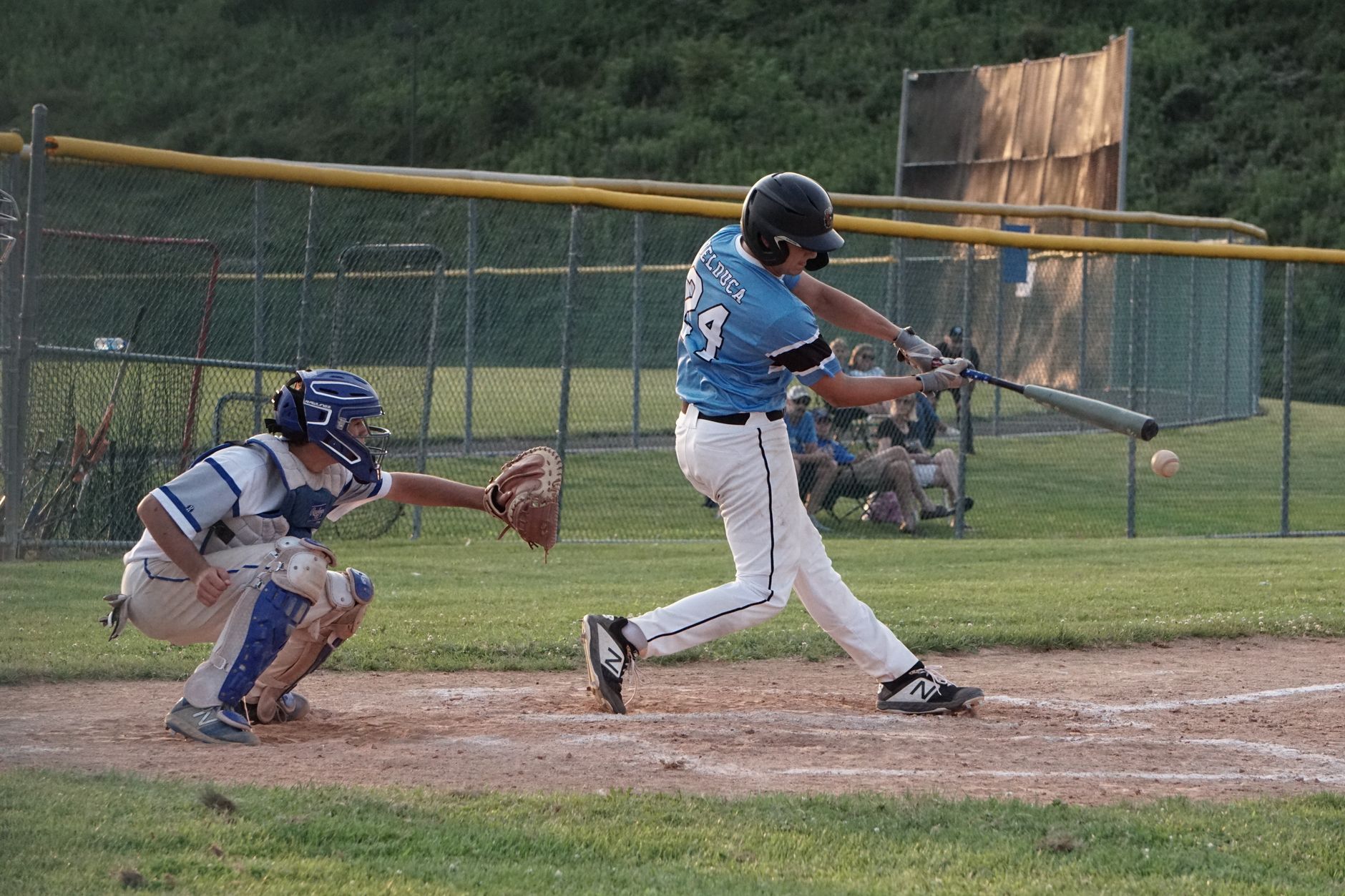 Action-packed baseball scene capturing the batter mid-swing with the catcher ready.