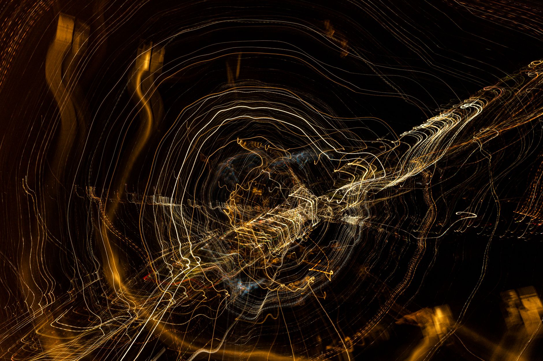 Swirling light trails create an abstract pattern against a dark background, evoking motion and energy.